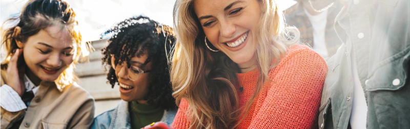 Eine Gruppe Frauen und Männer, die ins Smartphone schauen