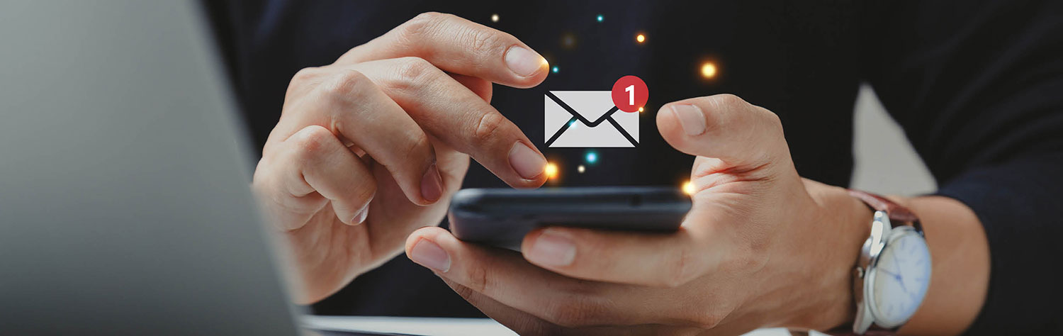 Hände eines Mannes, die ein Smartphone halten. darüber ist ein Email-Icon.
